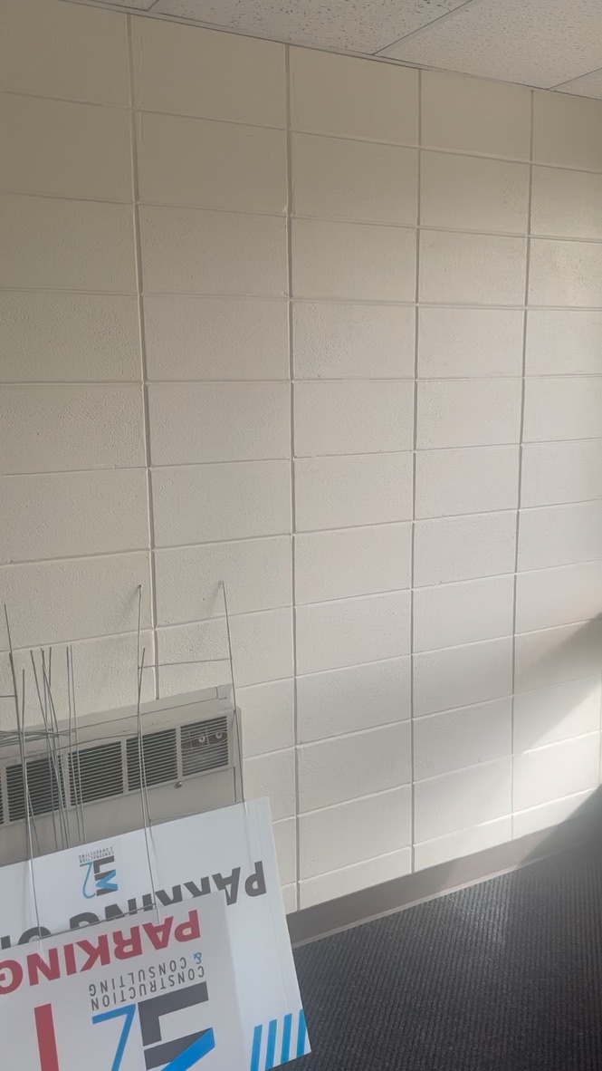 Room with cinder block wall and window AC unit